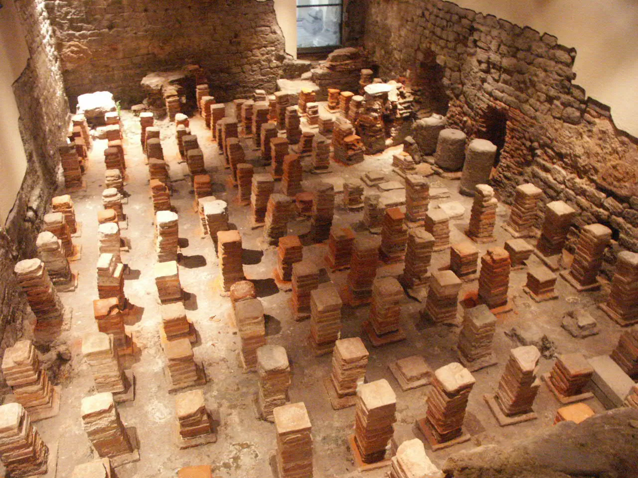Caldarium from the Roman Baths at Bath, The floor had been removed to reveal the empty spaces, which hot air flowed through to heat the floor tiles.